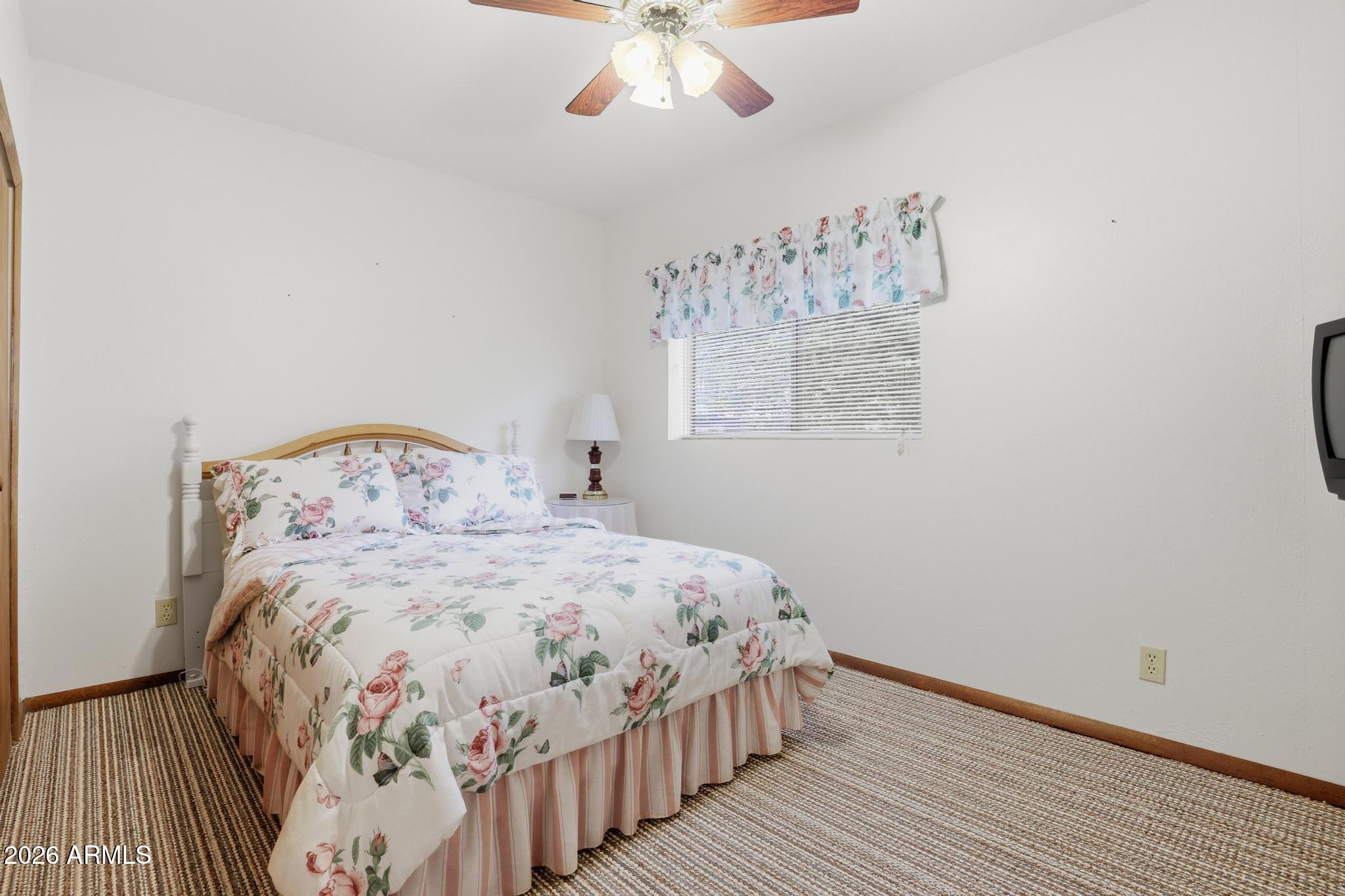 223 Thompson Road Payson, AZ 85541 - Photo 15 of 22 a bedroom with a large bed and a chandelier