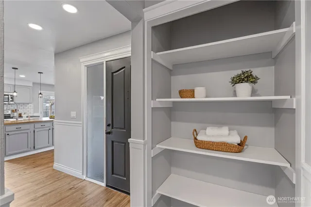 a hallway with view of kitchen and wooden floor