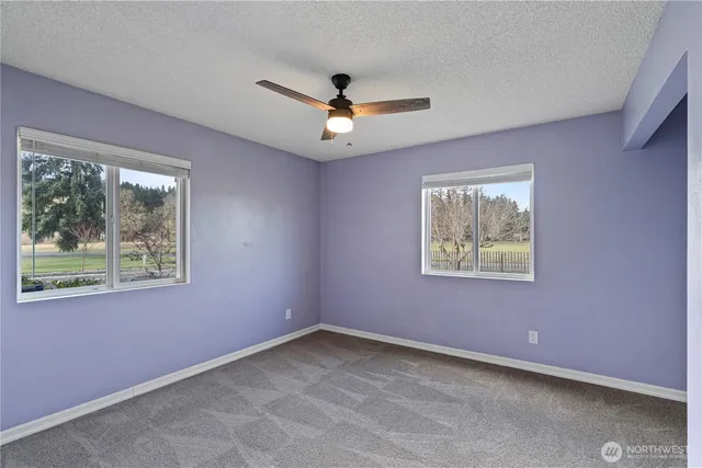 an empty room with a window and a ceiling fan