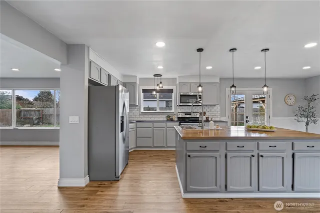 a kitchen with stainless steel appliances granite countertop a refrigerator and a stove top oven