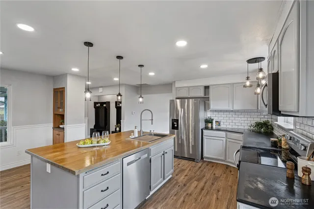 a large kitchen with a large counter top appliances and cabinets