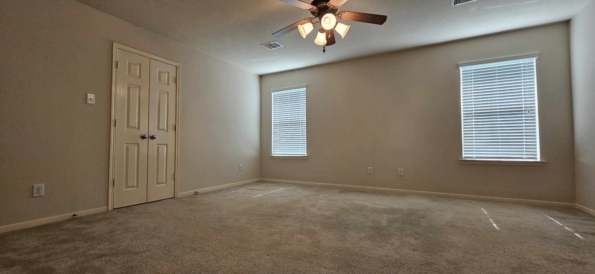 930 Sage Street Baytown, TX 77521 - Photo 20 of 27 an empty room with a chandelier fan and windows