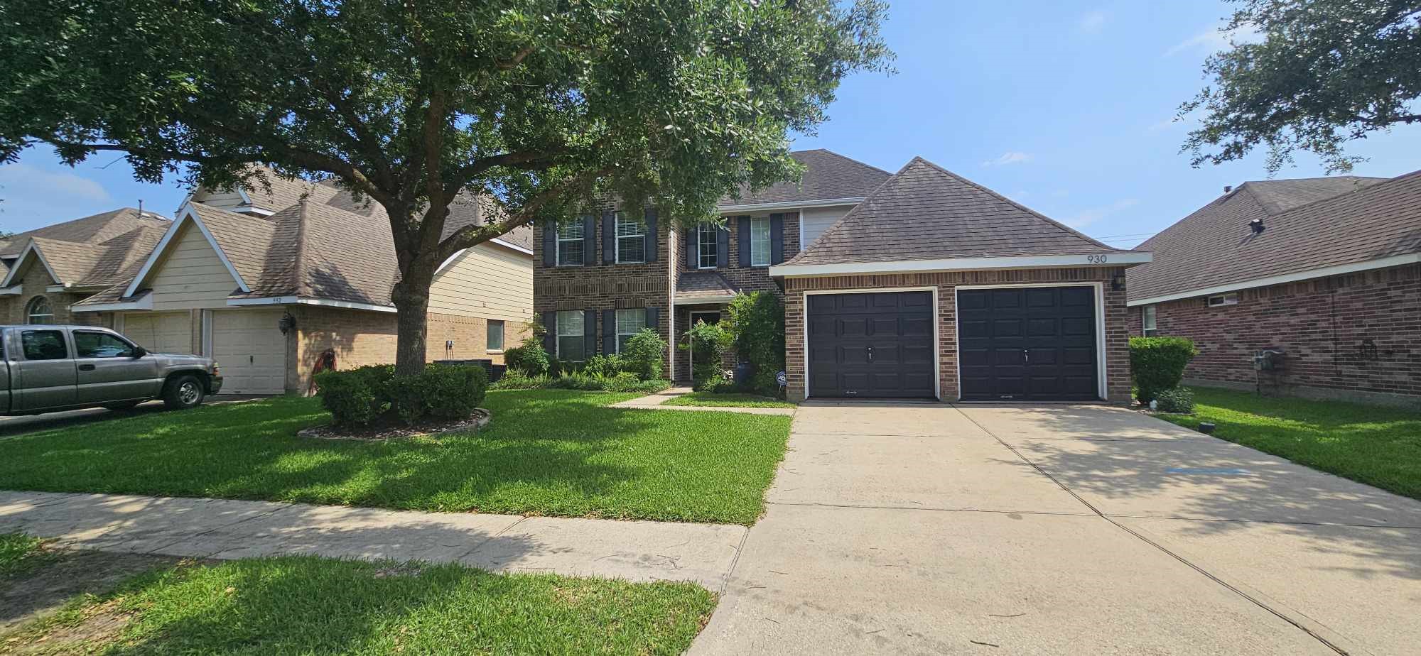 930 Sage Street Baytown, TX 77521 - Photo 2 of 27 a front view of a house with a garden and trees