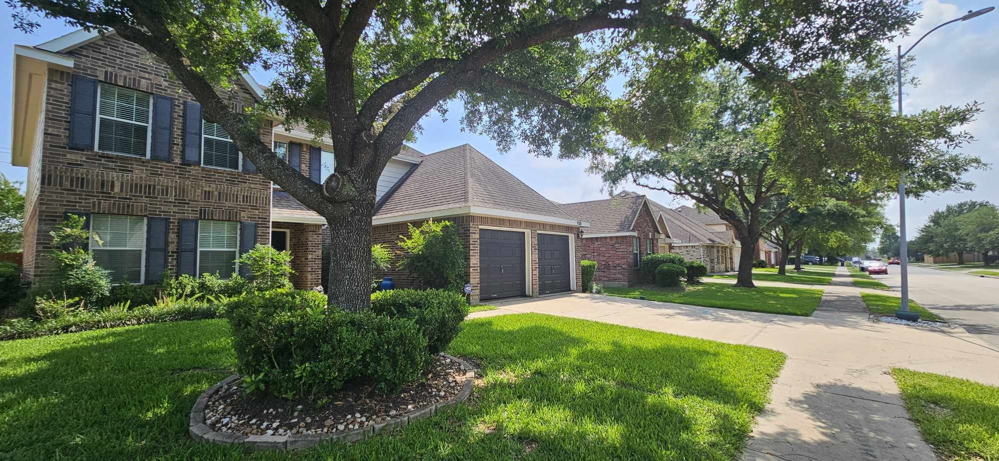 930 Sage Street Baytown, TX 77521 - Photo 4 of 27 a front view of a house with a yard and large tree