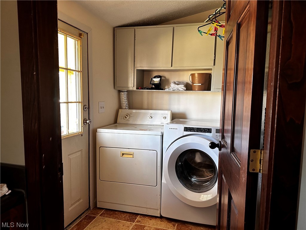 4944 Higley Road Rome, OH 44085 - Photo 26 of 28 Laundry area featuring cabinets, light tile flooring, independent washer and dryer, and a healthy amount of sunlight