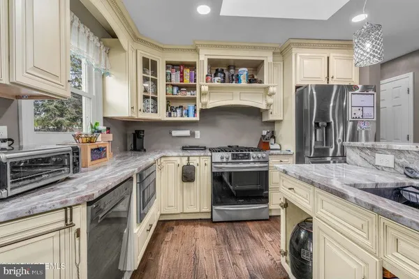 a kitchen with stainless steel appliances granite countertop a stove a sink and a refrigerator
