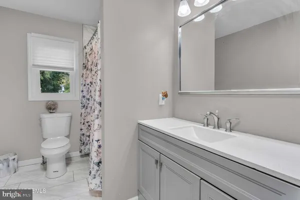 a bathroom with a sink toilet a mirror and shower