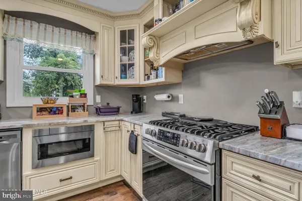 a kitchen with stainless steel appliances granite countertop a stove and a white cabinets