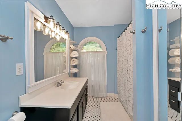 a bathroom with a sink a mirror and a shower