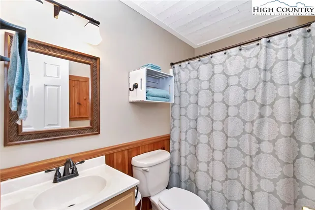 a bathroom with a sink mirror and toilet