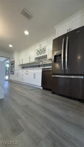a large kitchen with stainless steel appliances and a refrigerator