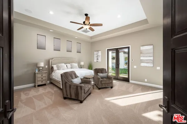 a spacious bedroom with a bed couch and window