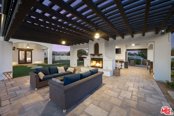 a living room with patio furniture and a fireplace
