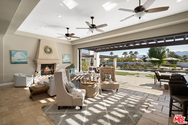 a living room with fireplace furniture and a large window