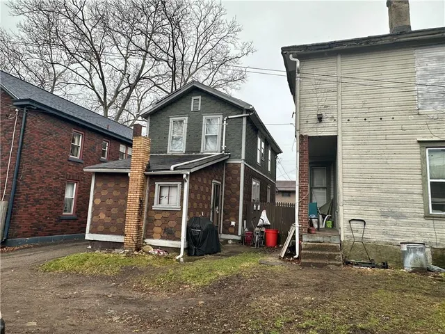 a view of a house with a yard and large tree