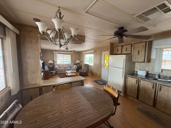 a kitchen with stainless steel appliances granite countertop a refrigerator a stove a sink dishwasher and white cabinets with wooden floor