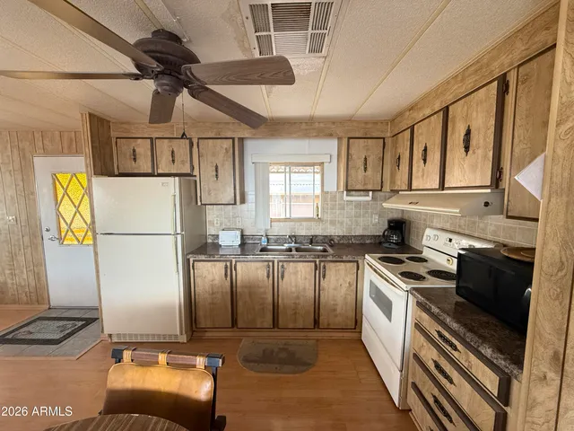 a kitchen with stainless steel appliances granite countertop a stove a washer and dryer with wooden floor