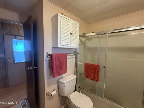 a bathroom with a granite countertop sink a mirror and shower