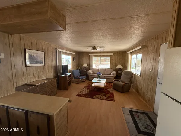 a living room with furniture a flat screen tv and a window