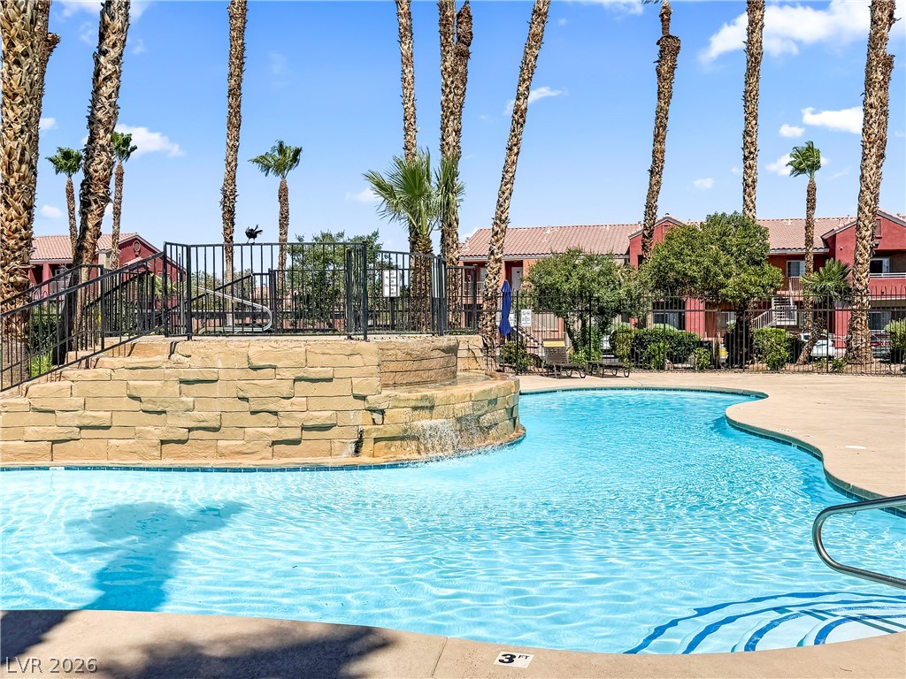 4730 East Craig Road, Unit 1053 Las Vegas, NV 89115 - Photo 29 of 32 A refreshing pool awaits, complete with a rock waterfall and surrounding palms for a resort-like atmosphere.