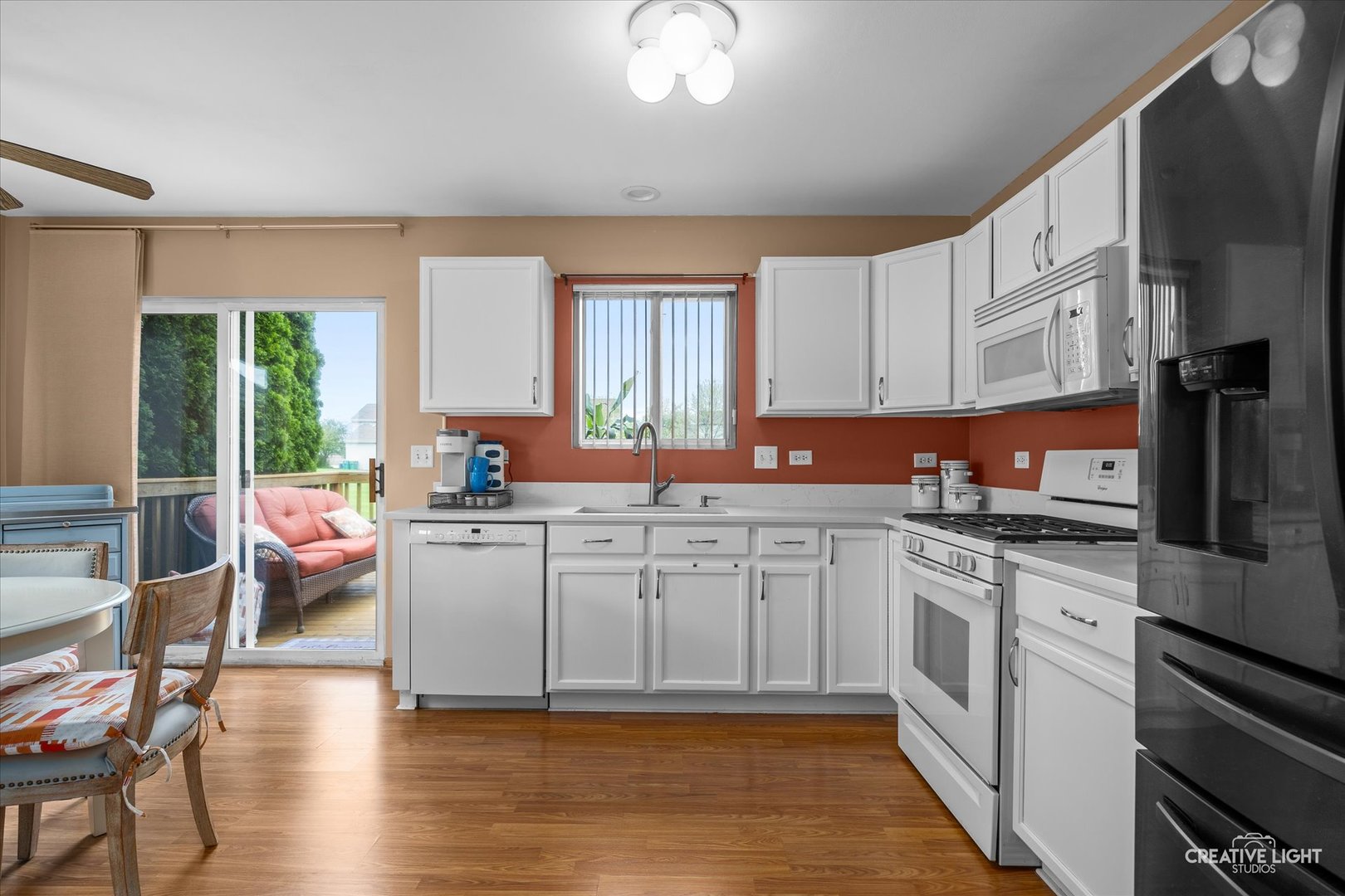 645 Chestnut Ridge Minooka, IL 60447 - Photo 5 of 20 a kitchen with stainless steel appliances granite countertop a stove top oven a sink dishwasher a dining table and chairs with wooden floor