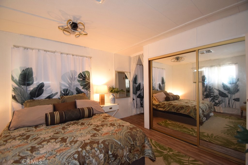 7425 Church Street, Unit 10 Yucca Valley, CA 92284 - Photo 15 of 24 a bedroom with a bed and wooden floor