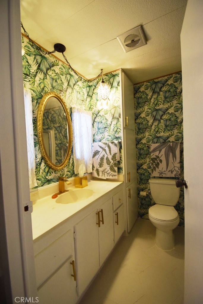 7425 Church Street, Unit 10 Yucca Valley, CA 92284 - Photo 16 of 24 a bathroom with a granite countertop toilet sink and mirror
