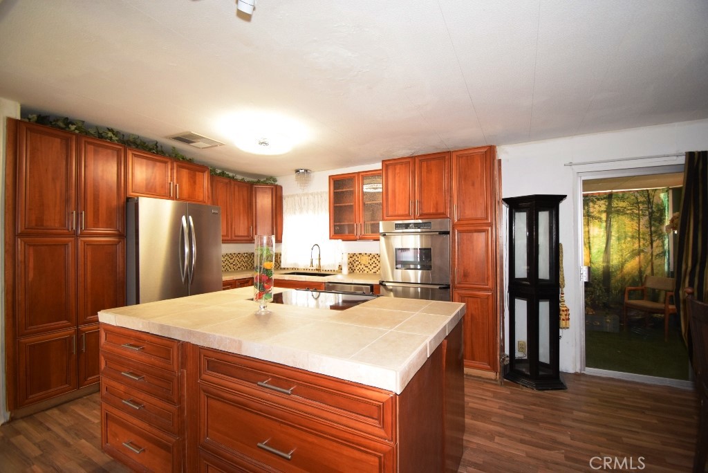 7425 Church Street, Unit 10 Yucca Valley, CA 92284 - Photo 10 of 24 a kitchen with stainless steel appliances a refrigerator and a stove top oven