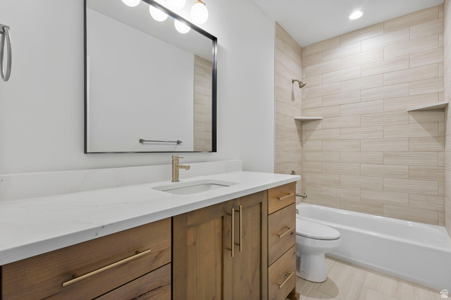 728 East Mountain Road North Ogden, UT 84414 - Photo 23 of 28 Bathroom featuring a wood-finish vanity with gold-tone hardware, white countertop, and an undermount sink