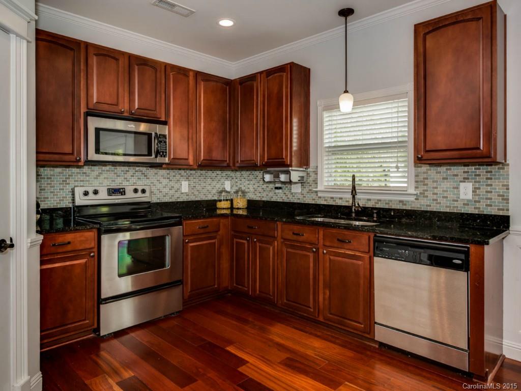 306 Allspice Road Fort Mill, SC 29708 - Photo 6 of 24 a kitchen with granite countertop wooden cabinets stainless steel appliances and a sink