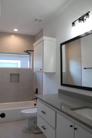 a bathroom with a sink a toilet and bathtub