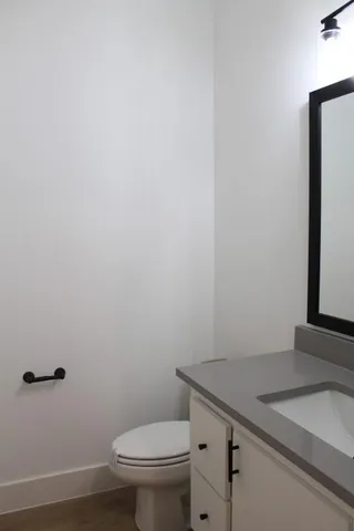 a bathroom with a granite countertop toilet and a sink