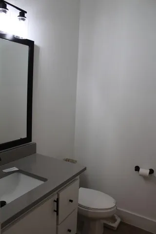 a bathroom with a granite countertop toilet and sink
