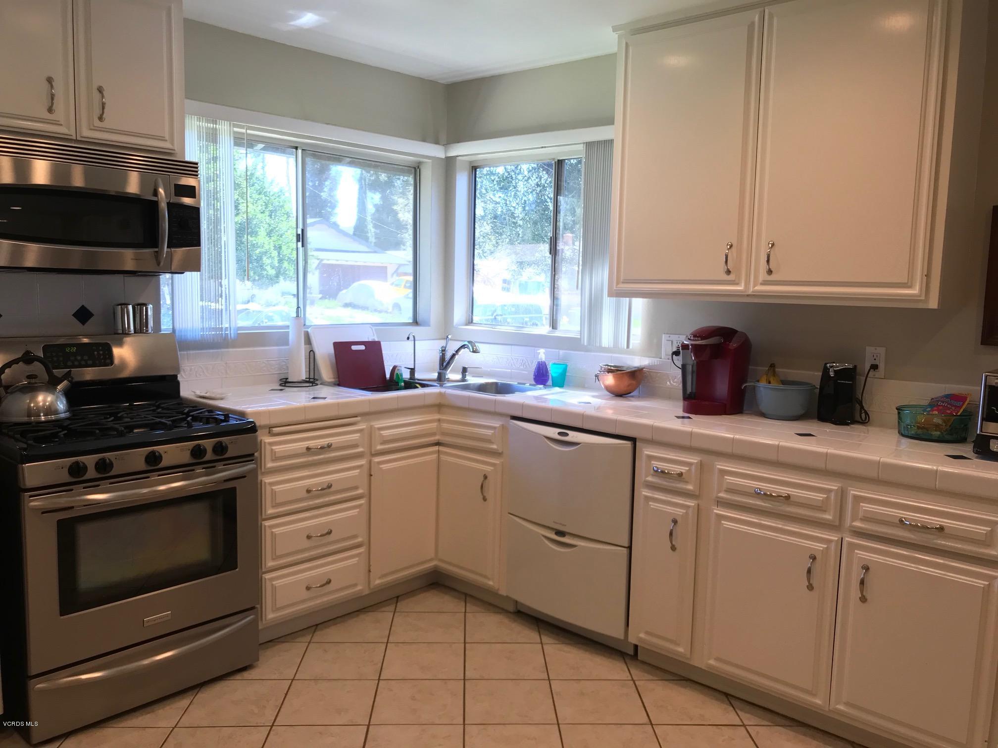 2227 Ralston Street Simi Valley, CA 93063 - Photo 11 of 35 a kitchen with white cabinets appliances and a window