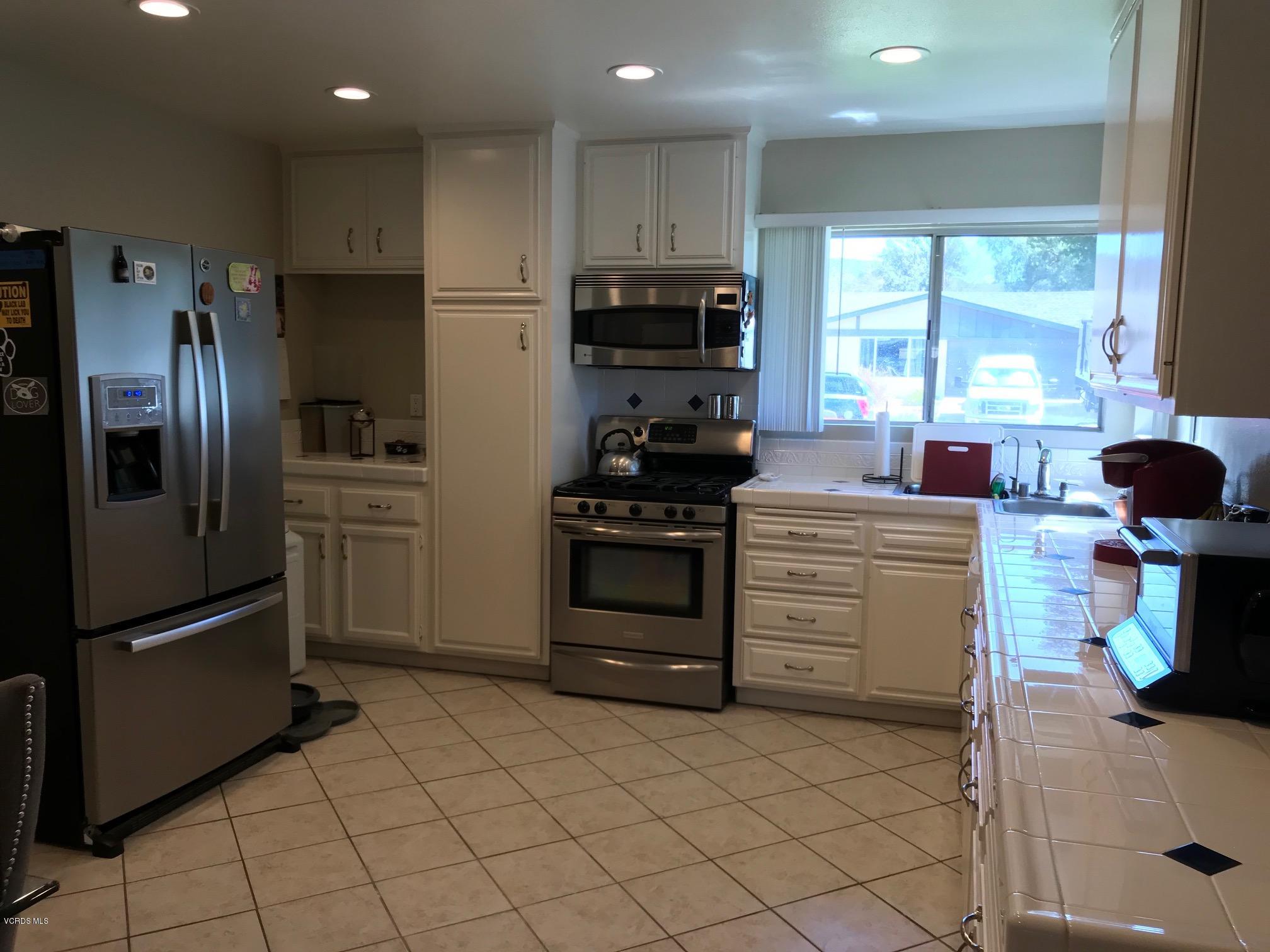 2227 Ralston Street Simi Valley, CA 93063 - Photo 9 of 35 a kitchen with a refrigerator and a stove top oven