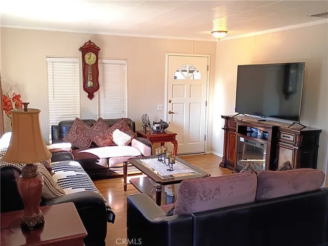 a living room with furniture a flat screen tv and kitchen view