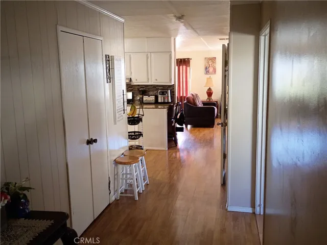 a living room with hard wood floors and a kitchen