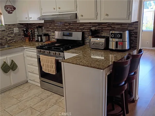 a kitchen with stainless steel appliances granite countertop a refrigerator and a stove