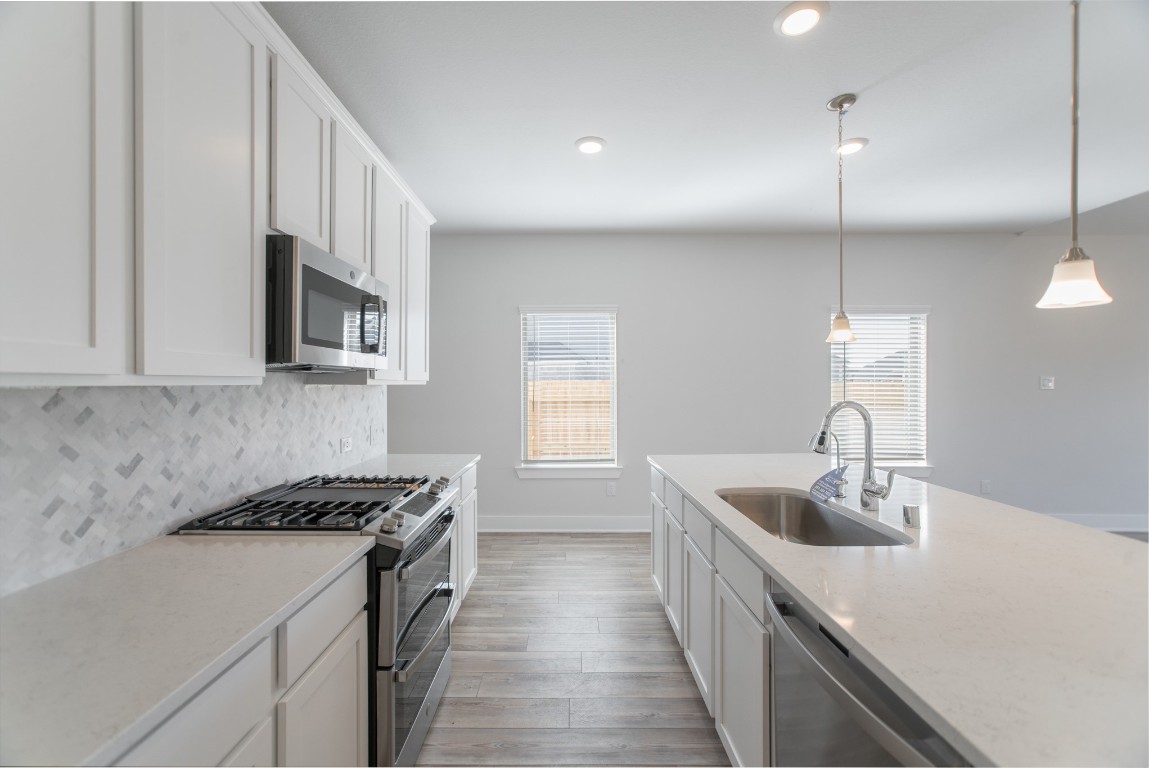 10627 Whitejacket Conroe, TX 77385 - Photo 13 of 46 a kitchen with stainless steel appliances granite countertop a sink a stove and a wooden floors