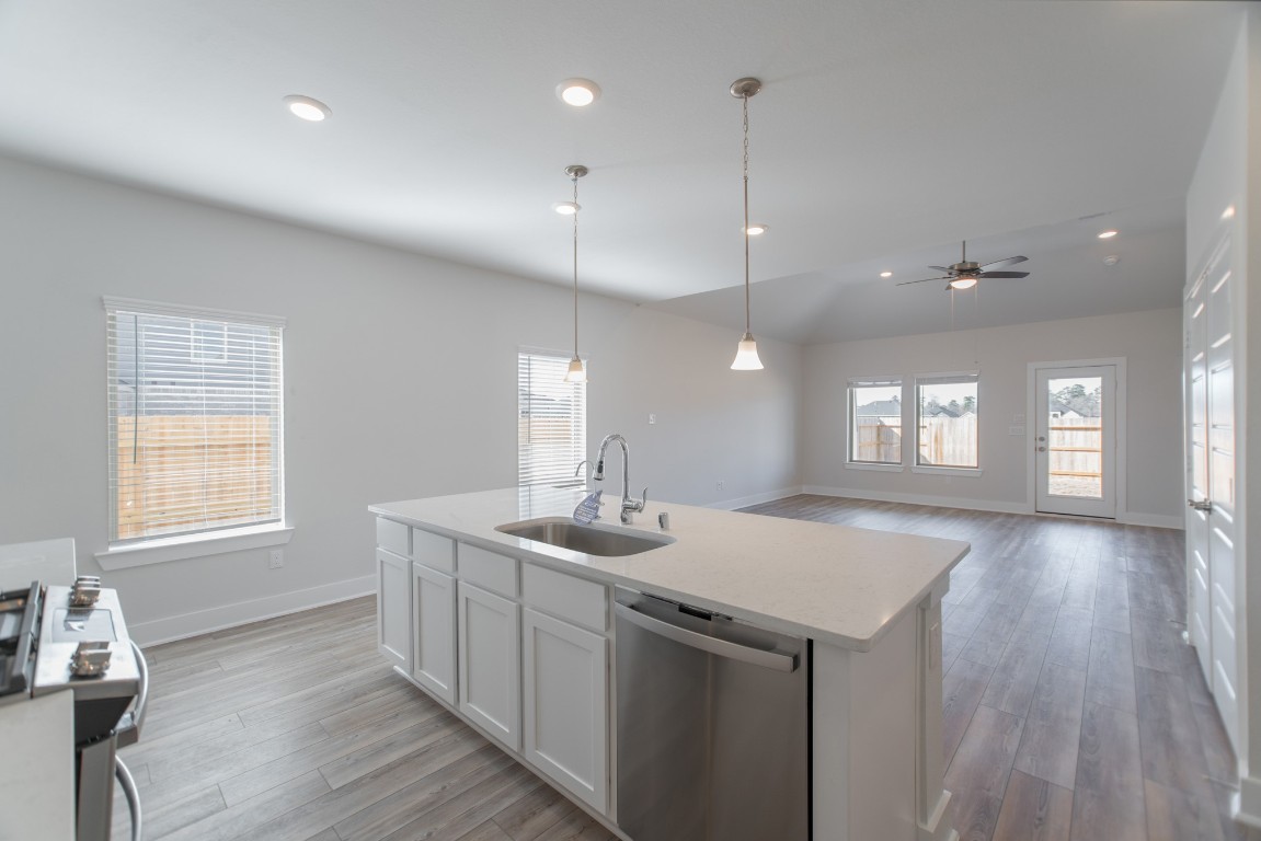 10627 Whitejacket Conroe, TX 77385 - Photo 14 of 46 a kitchen with a sink chandelier and wooden floor