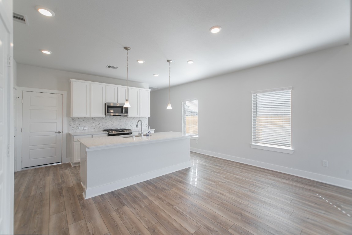 10627 Whitejacket Conroe, TX 77385 - Photo 17 of 46 a large kitchen with kitchen island a sink wooden floor and white stainless steel appliances