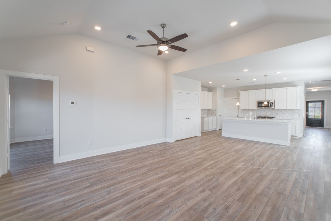 10627 Whitejacket Conroe, TX 77385 - Photo 20 of 46 a view of a livingroom with a kitchen island wooden floor and a ceiling fan