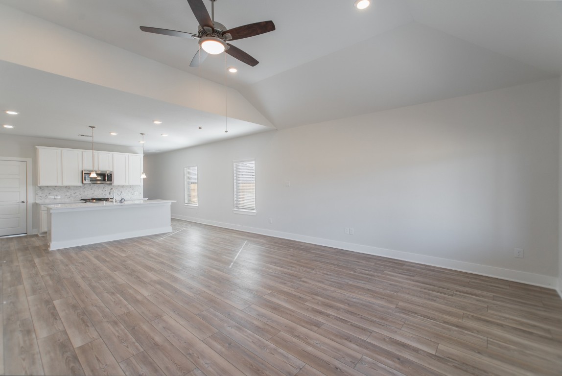 10627 Whitejacket Conroe, TX 77385 - Photo 22 of 46 a view of an empty room with wooden floor and a kitchen