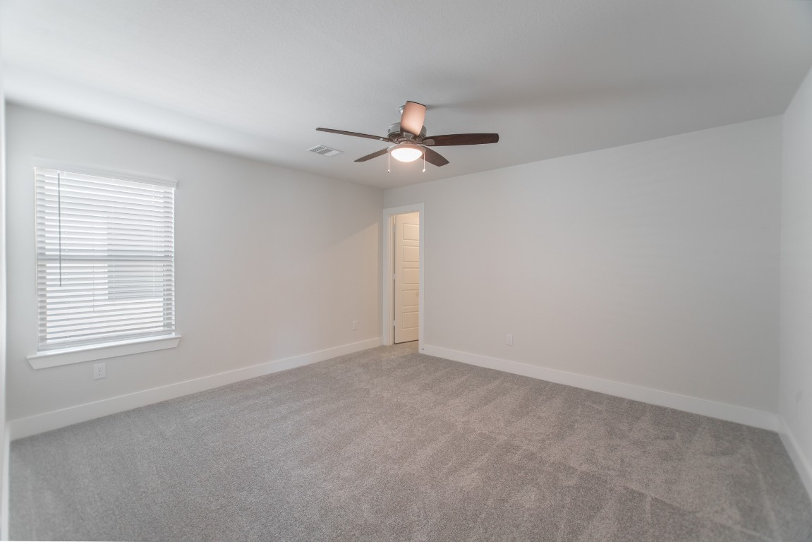 10627 Whitejacket Conroe, TX 77385 - Photo 36 of 46 a view of an empty room with a ceiling fan and a window