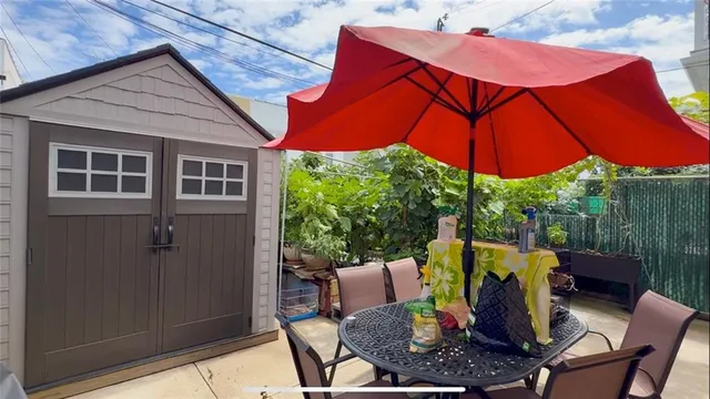 a view of a patio with table and chairs under an umbrella