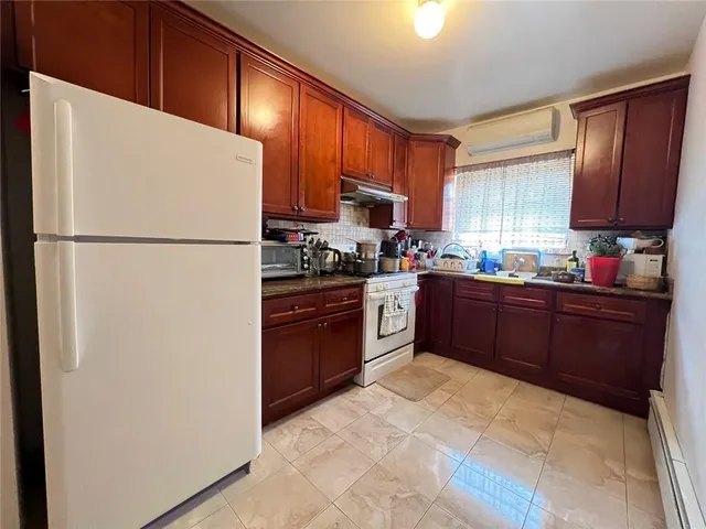 a kitchen with stainless steel appliances granite countertop a refrigerator stove a sink dishwasher and wooden cabinets