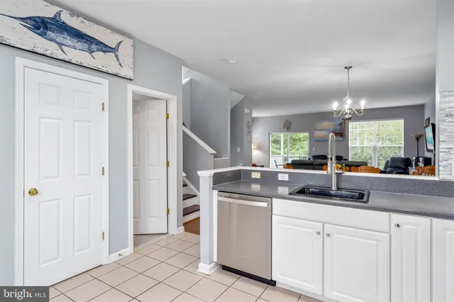 a kitchen with white cabinets and chandelier