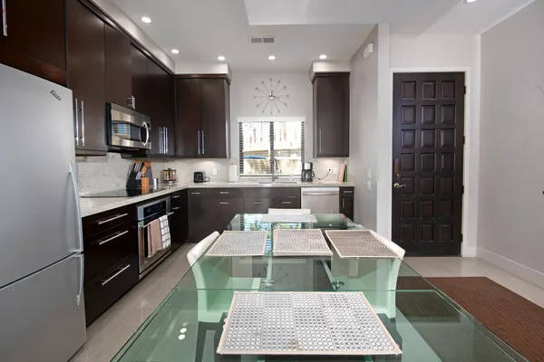 a kitchen with stainless steel appliances kitchen island granite countertop a refrigerator and a stove top oven