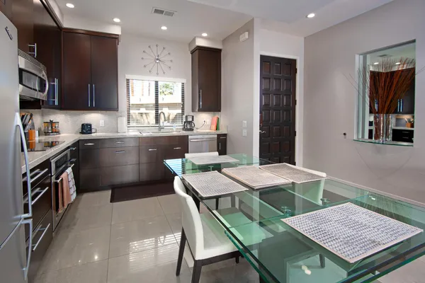 a kitchen with a table chairs sink and refrigerator