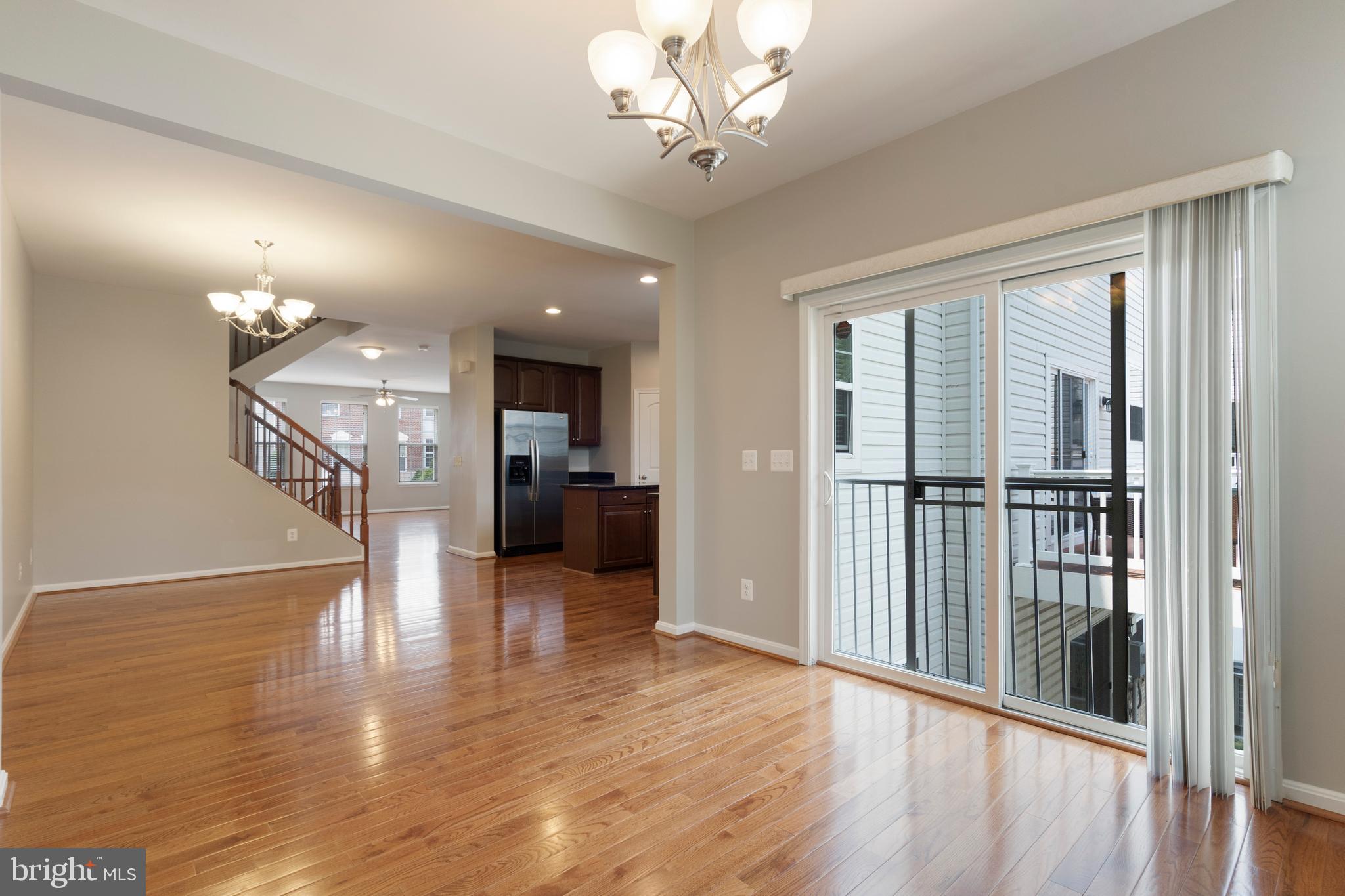 22672 Flowing Spring Square Brambleton, VA 20148 - Photo 6 of 35 a view of a hallway with wooden floor and a kitchen